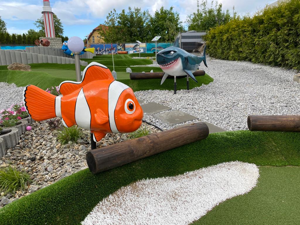 Kolorowe figury ryby Nemo i rekina na polu do minigolfa w miejscowości Rewal – realizacja Malpol.
