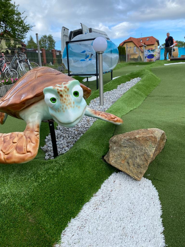 Realistyczna figura żółwia morskiego przy torze do gry w minigolfa w Rewalu.