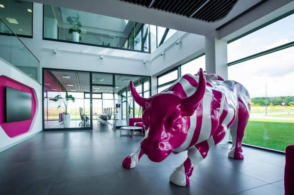 Nowoczesna figura byka TME z włókna szklanego (Modern 3D bull sculpture) - różowa makieta reklamowa w biurze - producent Malpol