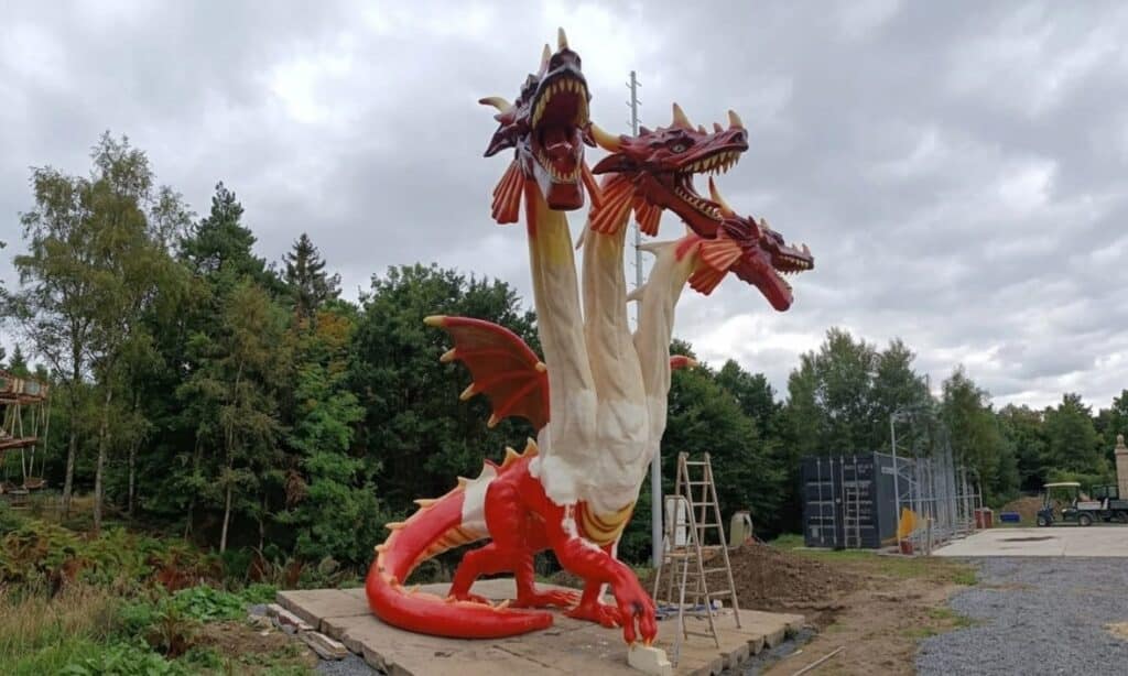 Finałowy etap montażu i prac wykończeniowych trójgłowego smoka XXL na terenie Skalka Family Park – integracja monumentalnej rzeźby z fundamentem i ostatnie poprawki malarskie na wysokości.